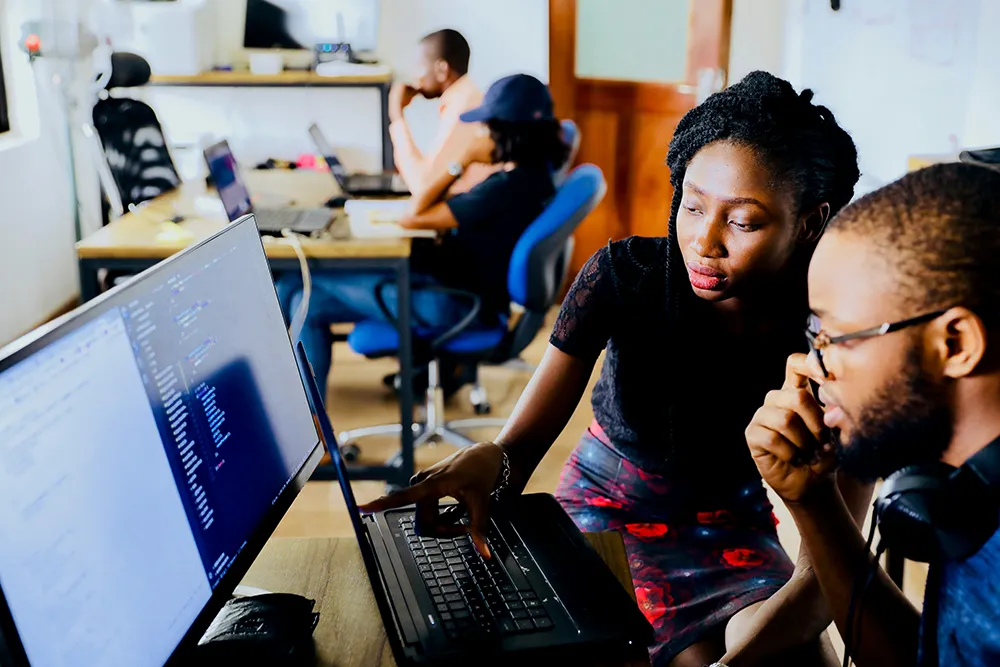 professional black woman demonstrating effective delegation with her male coworker software developer